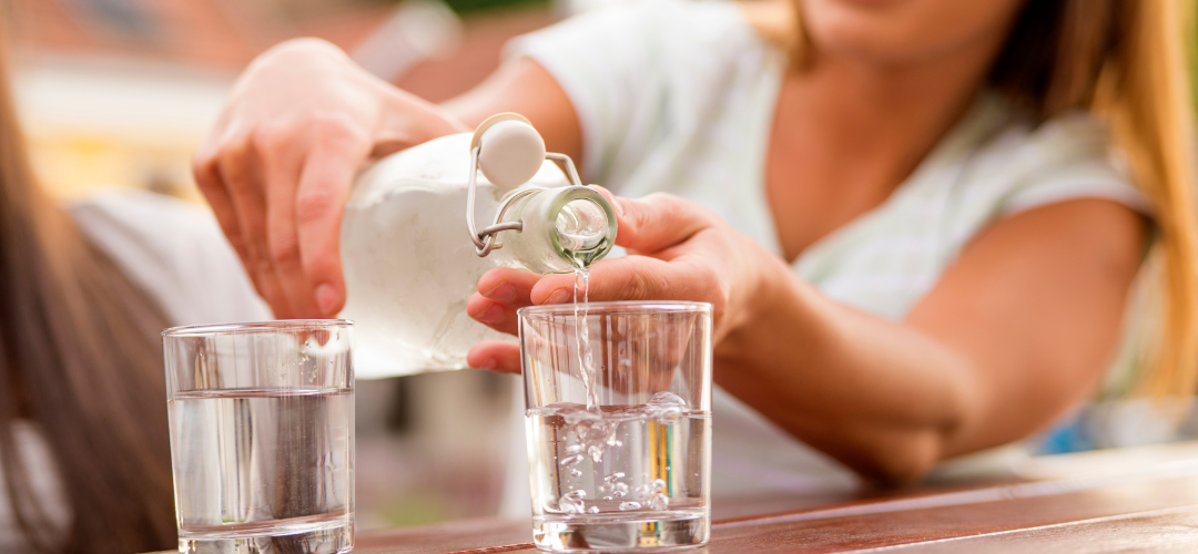A person pouring some water into a glass