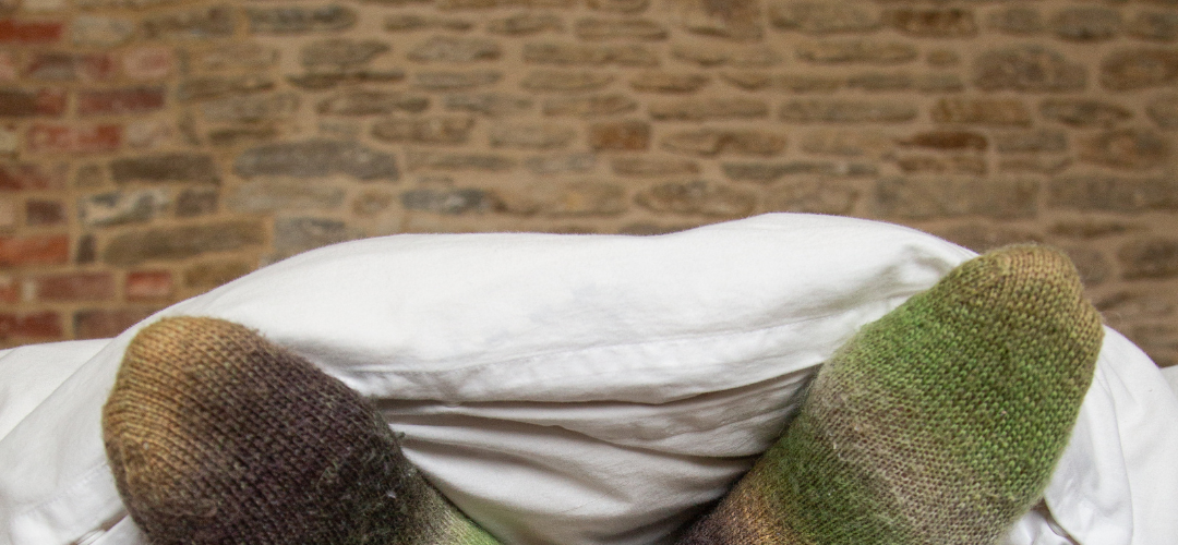 An image of feet in a bed,