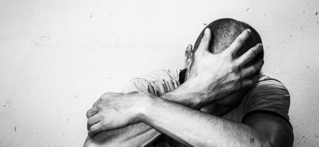 black and white image of a man with his head in his hands