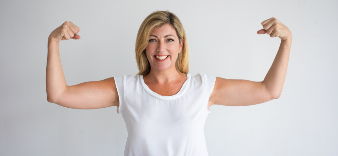 A woman standing with her arms up in a strong position
