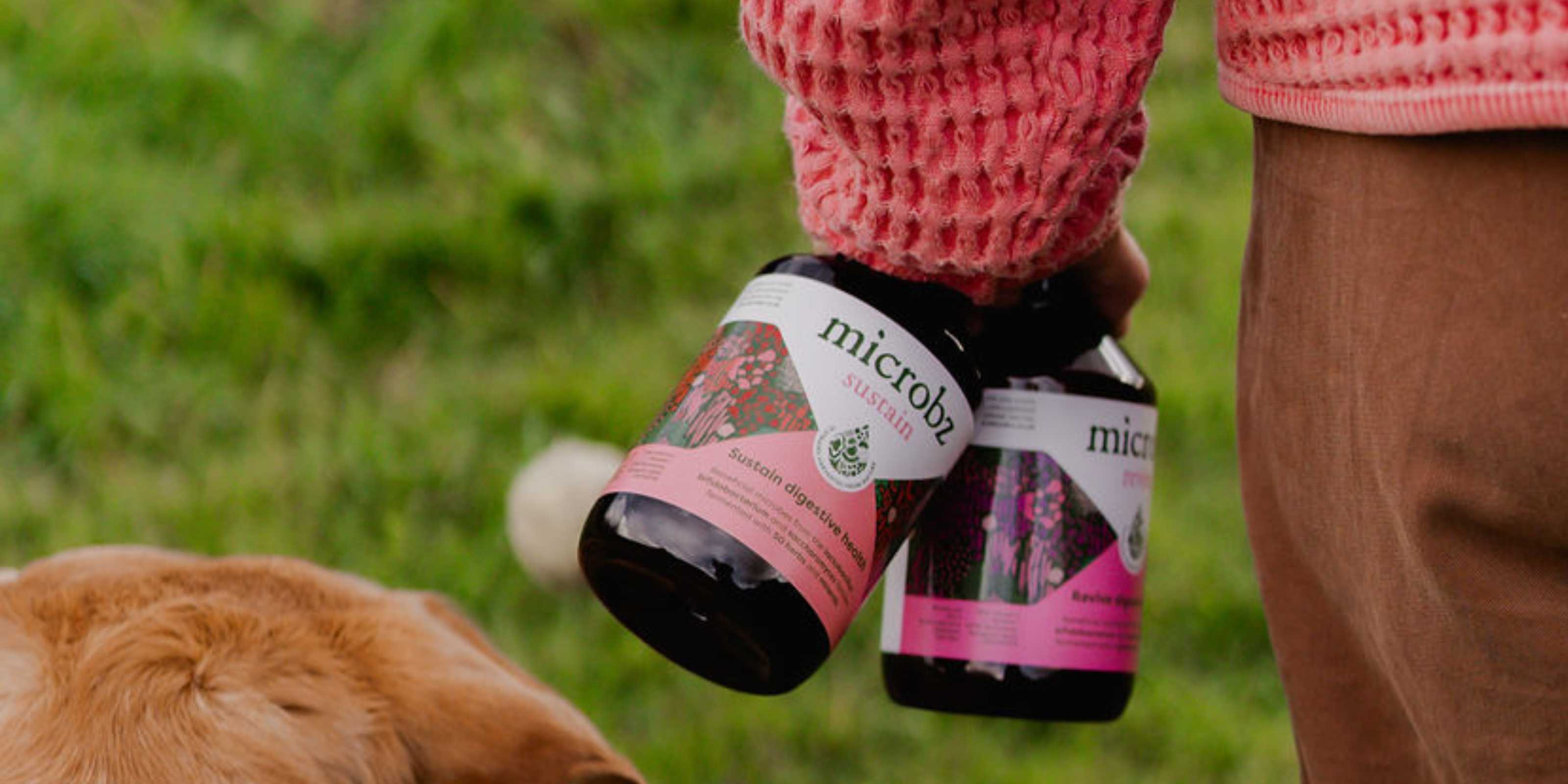 bottle of microbz sustain and microbz revive in a hand