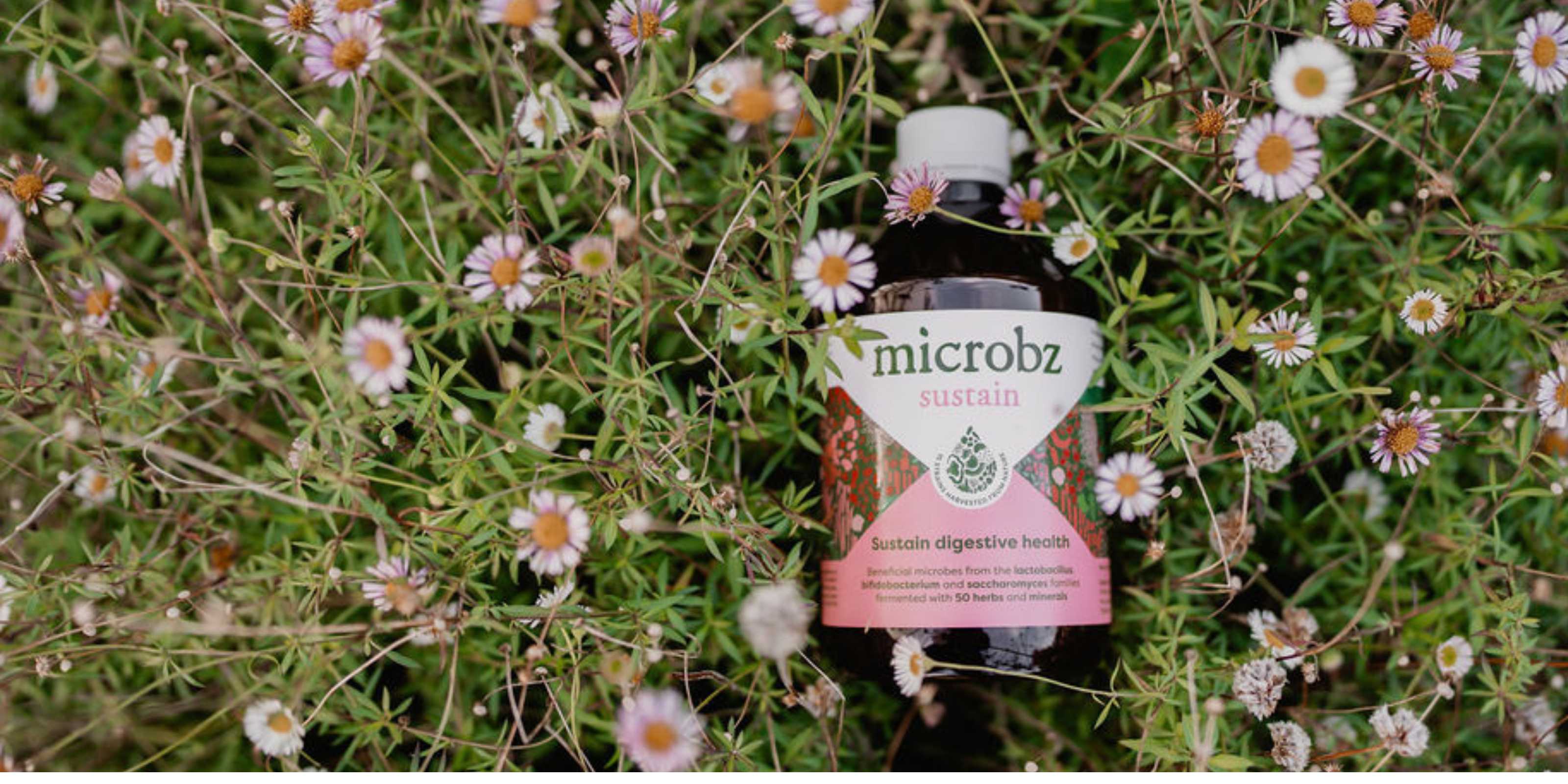 bottle of microbz sustain in flowers