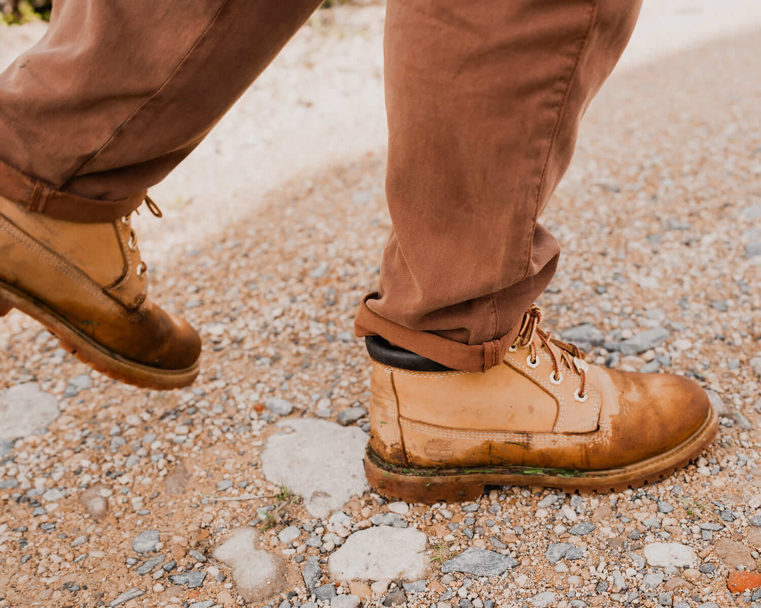 Close up of tan boots walking on gravel