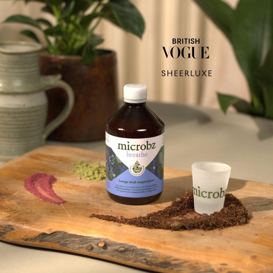 microbz bottle and cup on a wooden surface with plants in the background, featuring British Vogue Sheerluxe.
support your respiratory system