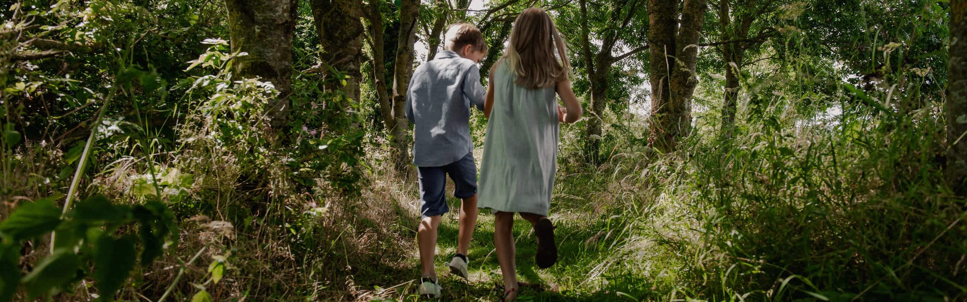 two children running through the woods
