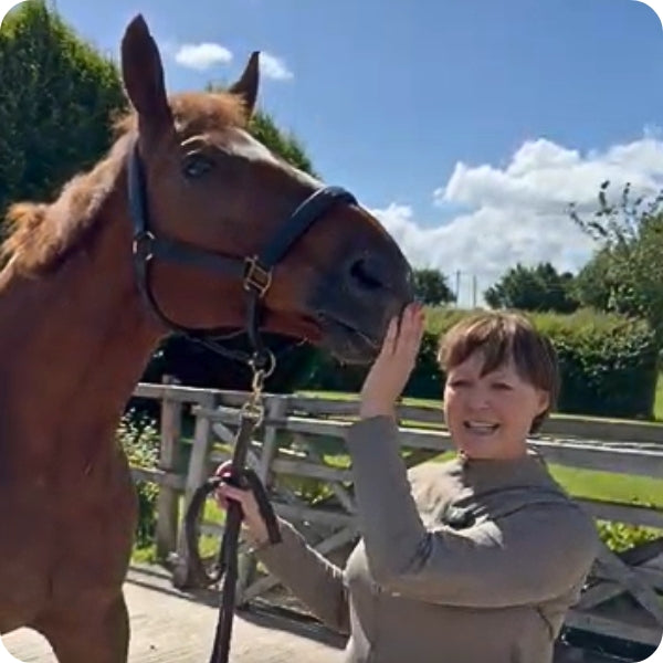 Rachel and her horse with her hand touching the horses mouth