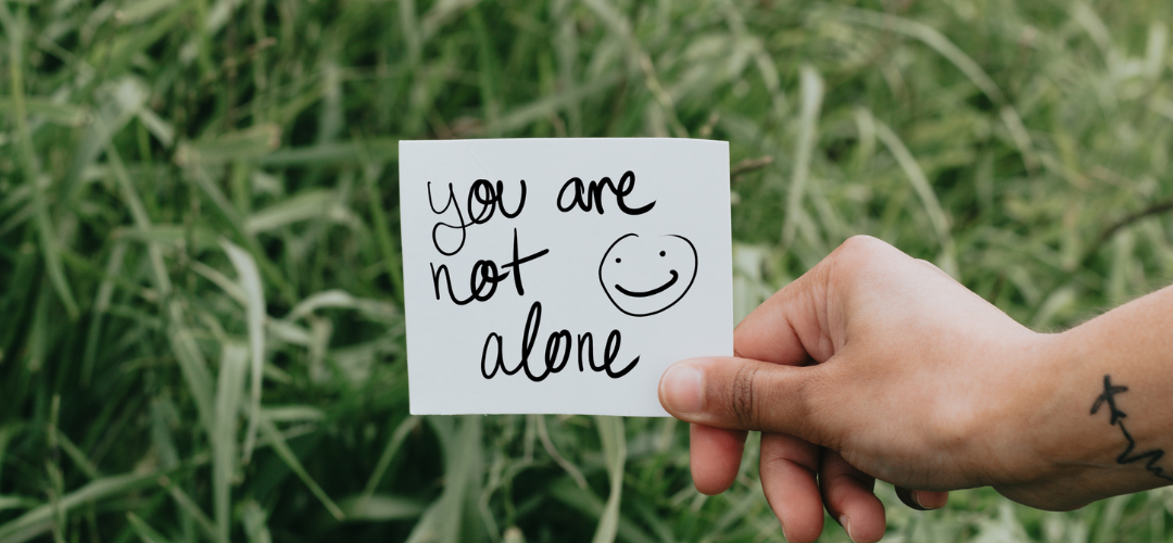 am image of a person holding a card that says 'you are not alone'