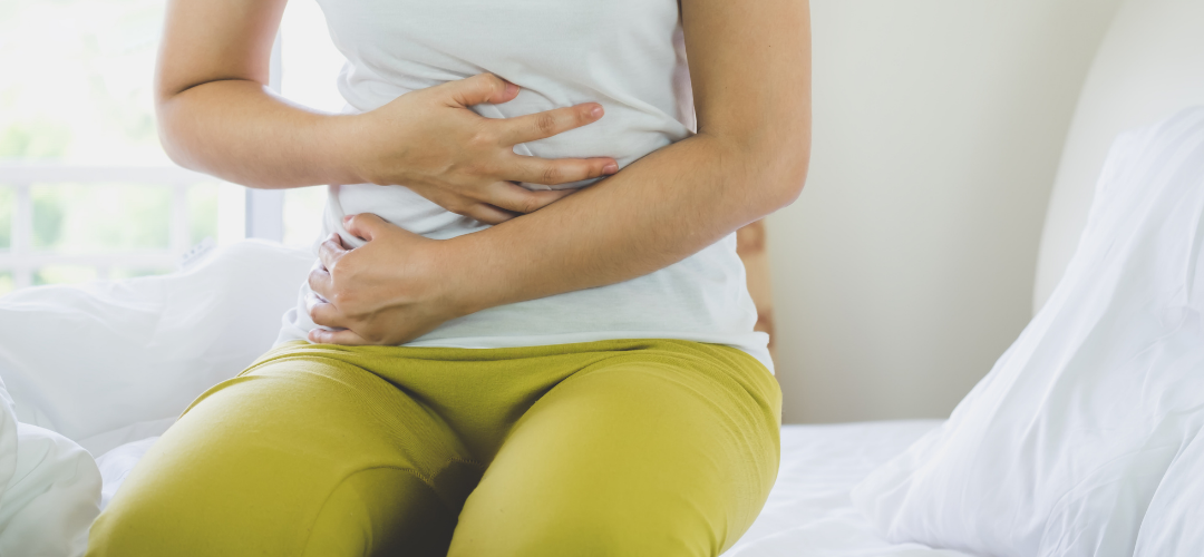 a woman holding her tummy with constipation