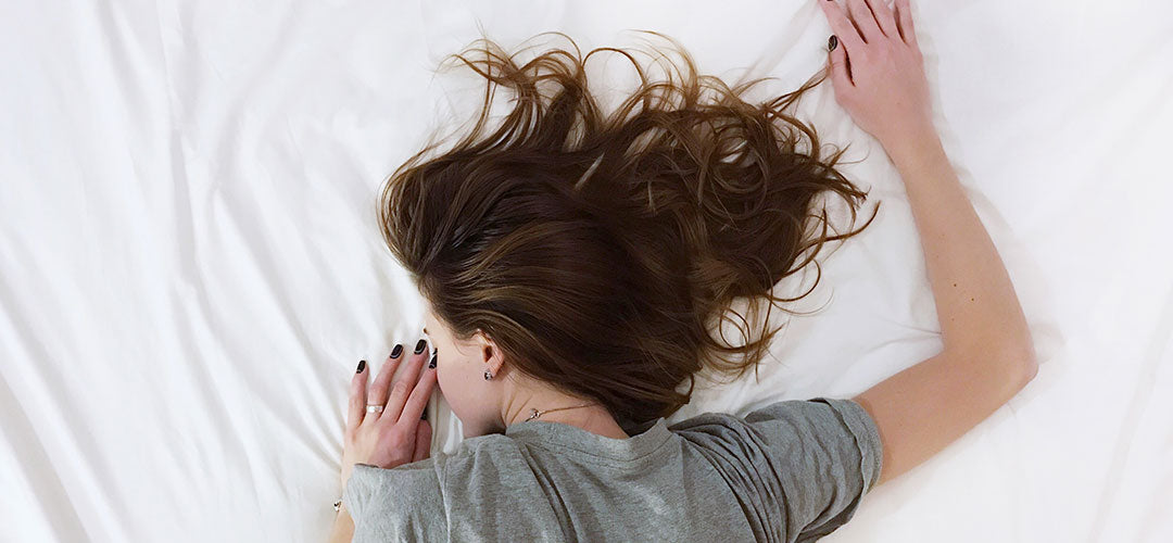 Woman lying down on bed sleeping