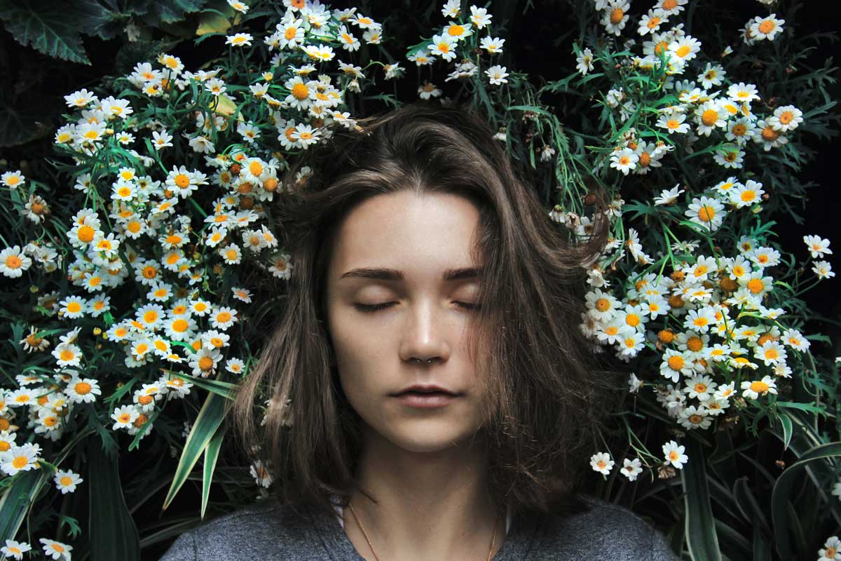 A woman with a healthy female flor lay in daisy representing flora