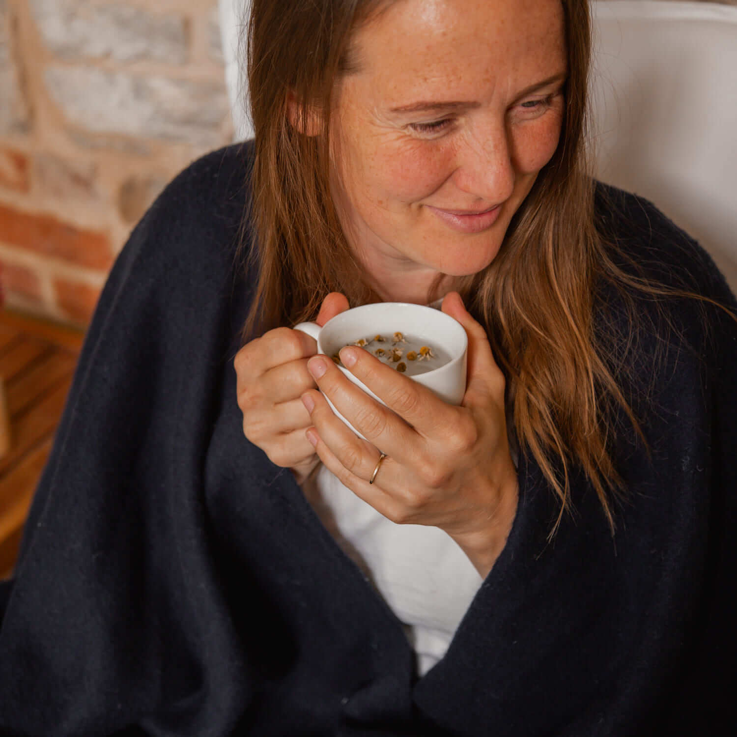 Katie Allen in a blanket holding a cup of chamomile tea