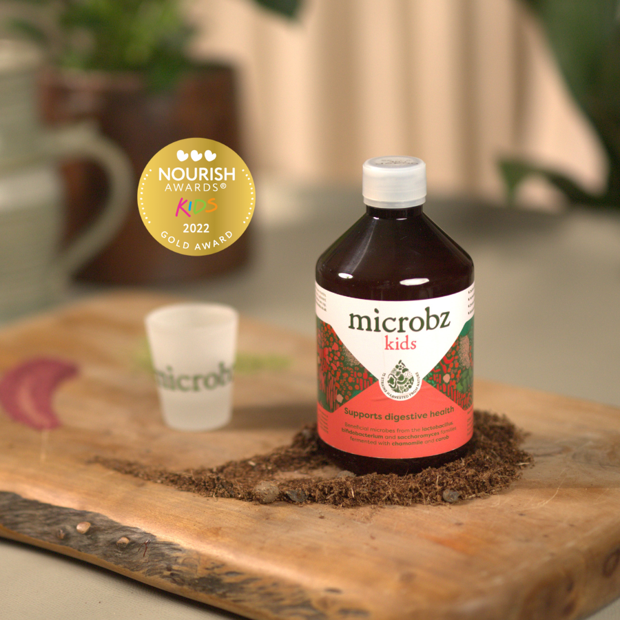 Bottle of microbz kids on a wooden surface with a Nourish Awards 2022 gold award badge.